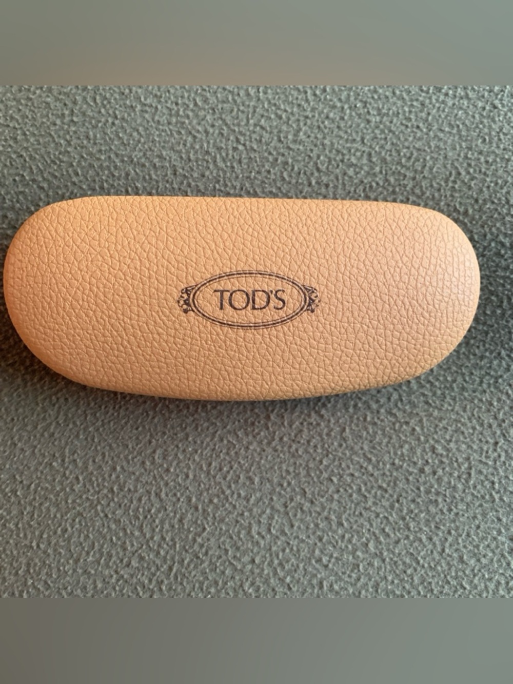 Tod’s tan clamshell glasses case with microfiber cloth.